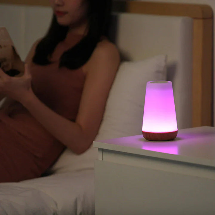 Lila LED-Nachtlicht auf Nachttisch, modernes Design, stimmungsvolle Beleuchtung, Schlafzimmer-Dekor.