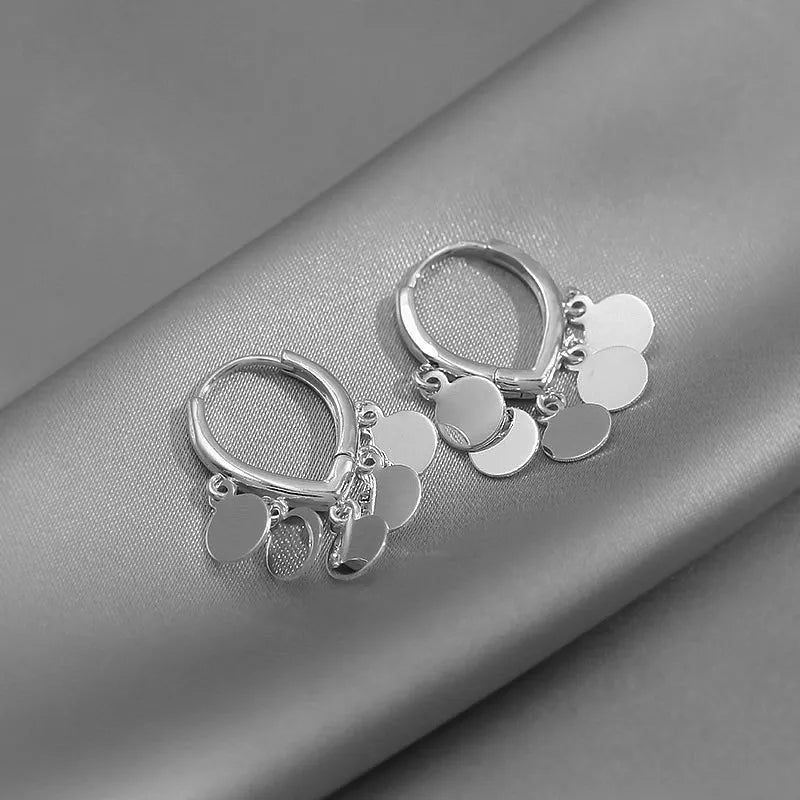 Silberne Creolen Ohrringe mit runden Anhängern, eleganter Schmuck für Damen.