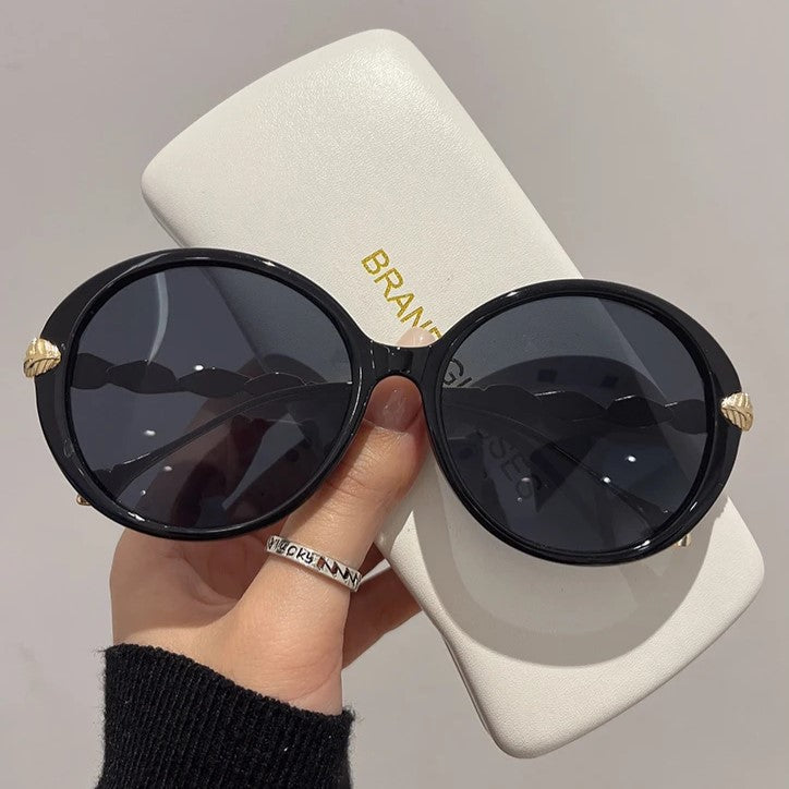 Schwarze runde Sonnenbrille mit Etui, Damenmode, UV-Schutz, stilvoll, elegant.