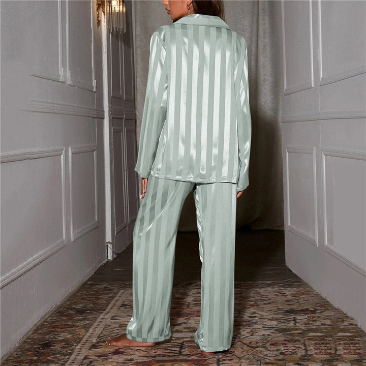 Frau in mintgrünem Satin-Pyjama mit Streifenmuster im Flur, Nachtwäsche, Damenmode.