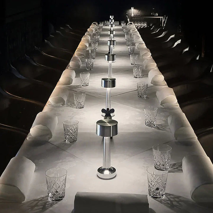 Langer, elegant gedeckter Tisch mit Kristallgläsern und modernen Salz- und Pfefferstreuern.