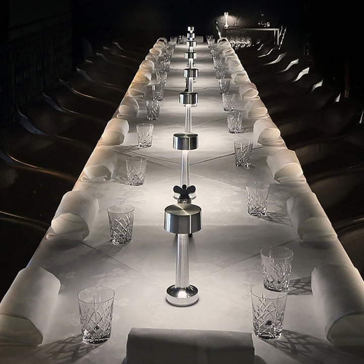 Langer, elegant gedeckter Tisch mit Kristallgläsern und silbernen Salz- und Pfefferstreuern.