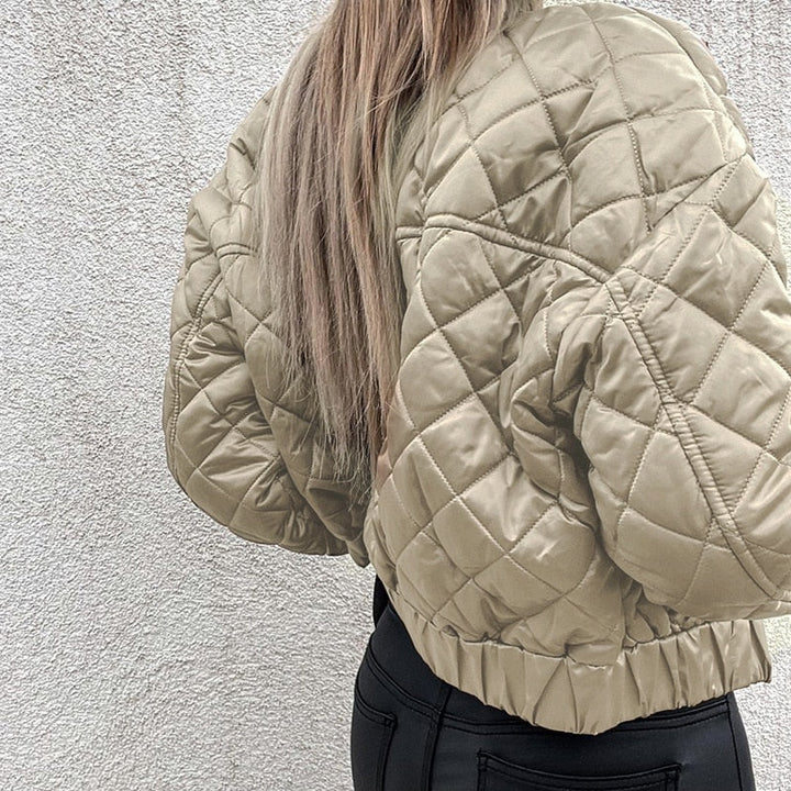 Frau in beige gesteppter Bomberjacke, Rückansicht, modisch, Herbstkleidung, Streetwear.