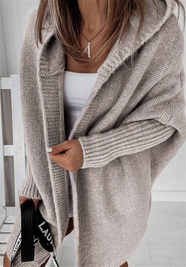 Frau in beigem Strickcardigan, weißem Top, mit Tasche, modisch, gemütlich, Herbstmode.