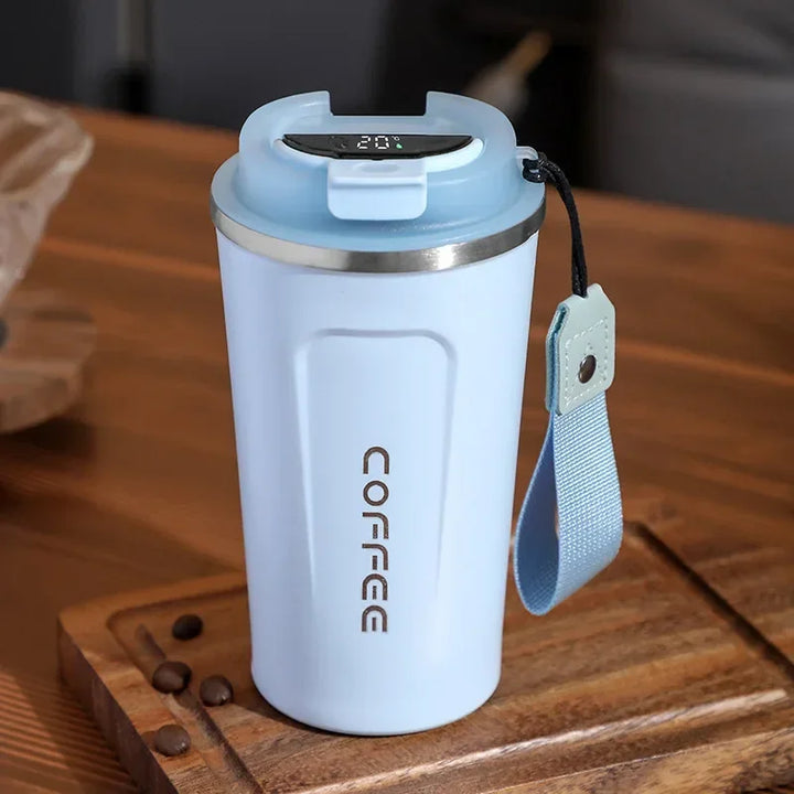 Blauer Thermobecher mit Deckel, COFFEE-Logo, Holzuntergrund, wiederverwendbar, umweltfreundlich.