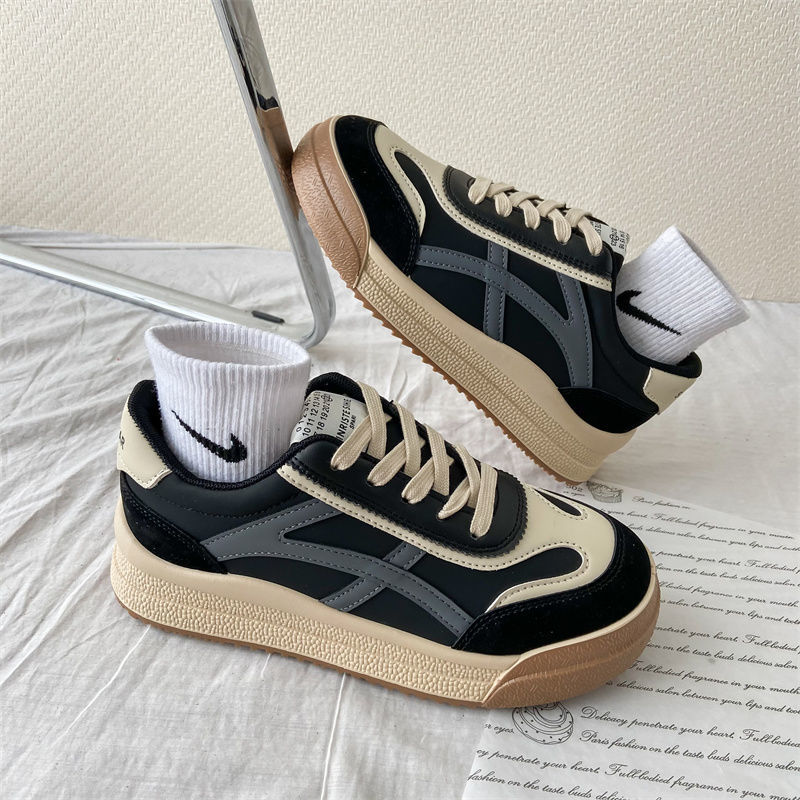 Schwarze und beige Sneaker mit weißen Socken, Retro-Design, auf weißem Hintergrund.