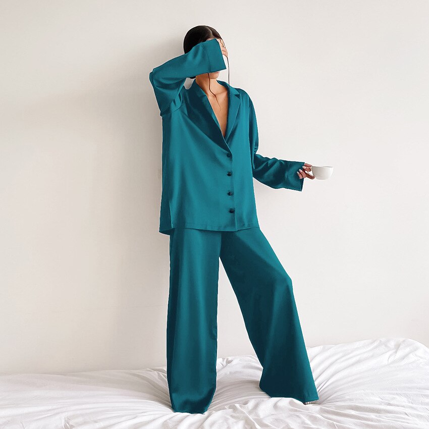 Frau in türkisfarbenem Satin-Pyjama mit Kaffeetasse, elegantes Nachtwäsche-Set.