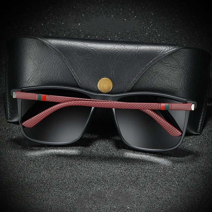 Schwarze Sonnenbrille mit roten Bügeln und Etui, modisches Accessoire, Unisex-Design.