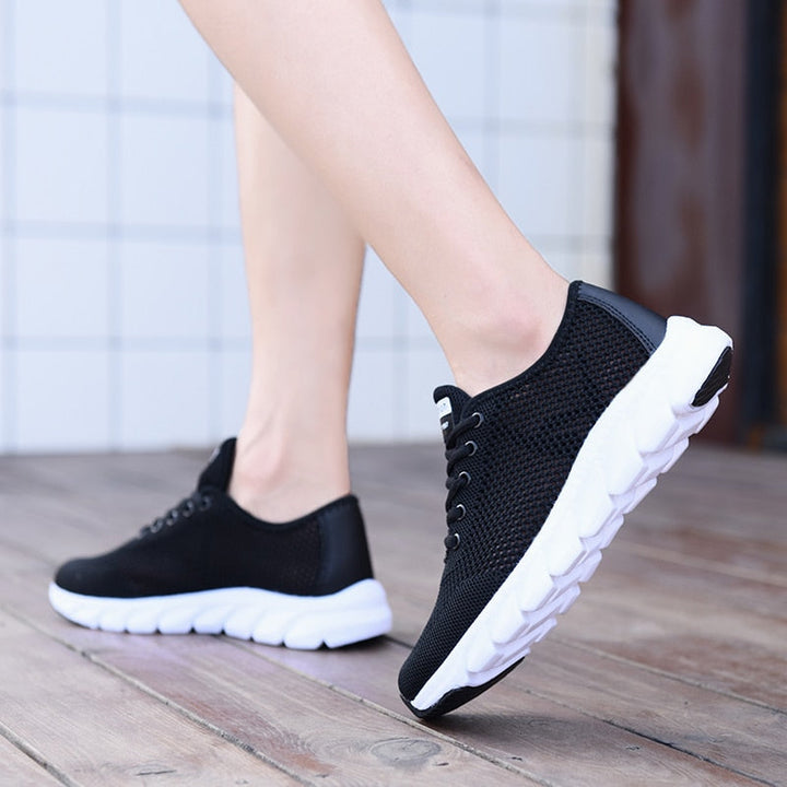 Schwarze Damen-Sneaker mit weißer Sohle, atmungsaktiv, ideal für Freizeit und Sport.