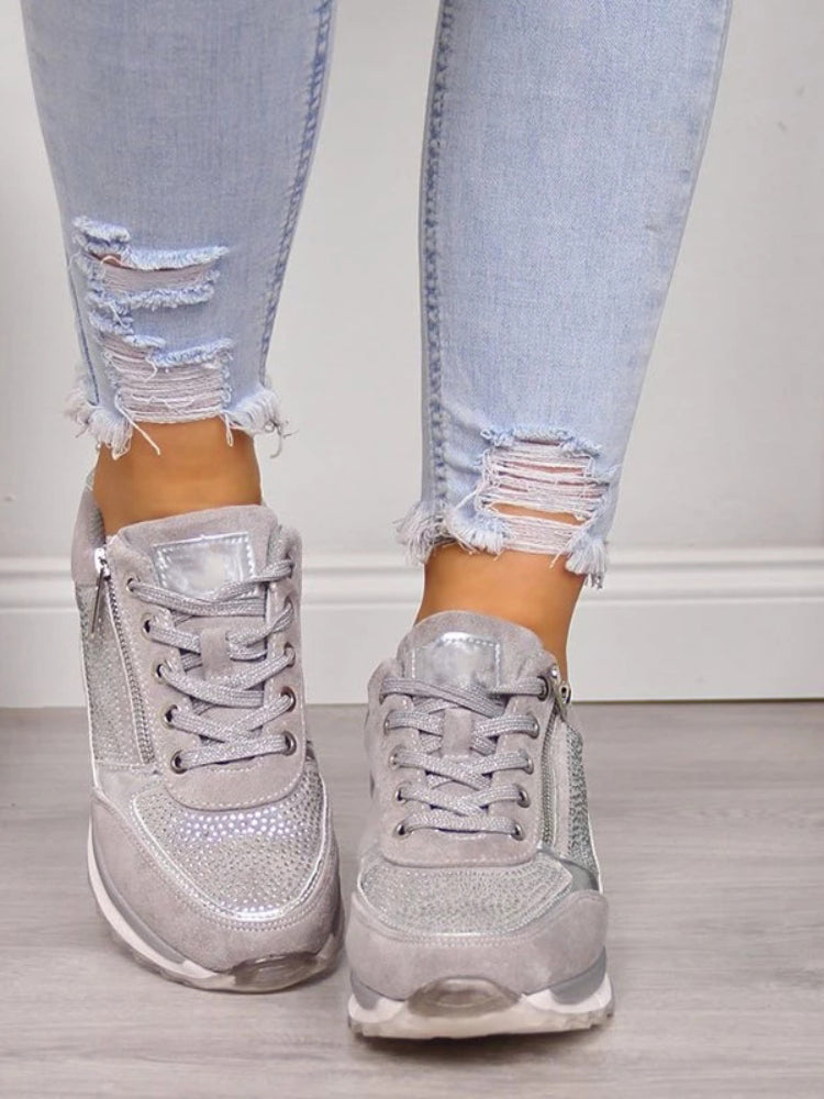 Graue Damen-Sneaker mit Glitzer, kombiniert mit zerrissenen Jeans, modisch und bequem.