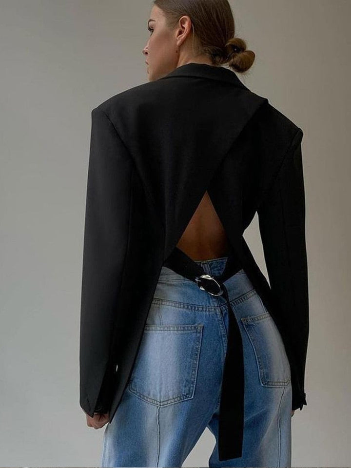 Frau in schwarzem Rückenausschnitt-Blazer und blauer Jeans, modisch, elegant, modern.