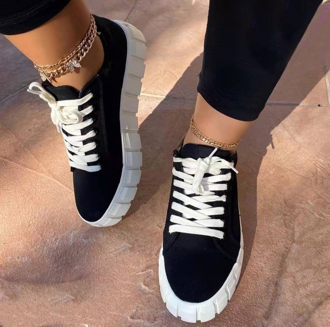Schwarze Damen-Sneaker mit weißer Sohle, Schnürsenkel, modisch, bequem, Straßenschuhe.