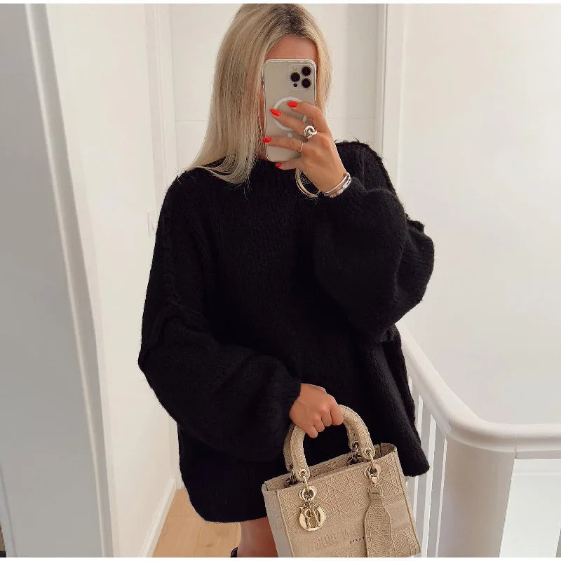 Frau in schwarzem Oversize-Pullover mit beiger Designer-Handtasche, Selfie im Spiegel.