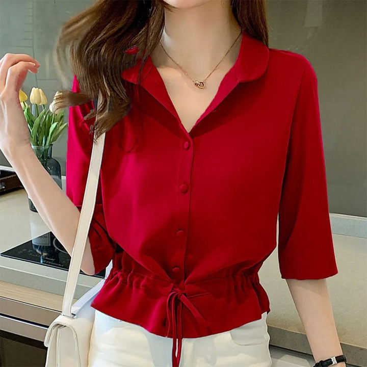 Frau in roter Bluse mit Knopfleiste und Kordelzug, modisch, elegant, Freizeitkleidung.