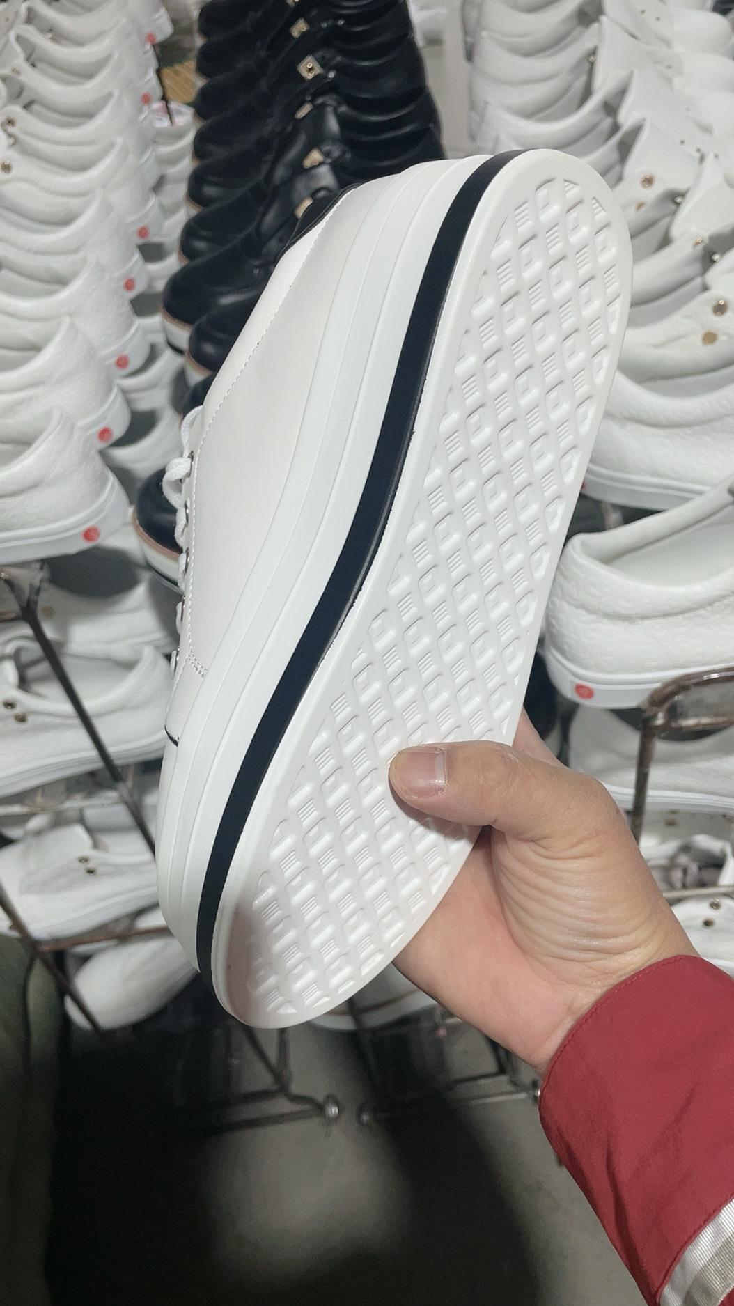 Weiße Sneaker mit dicker Sohle, handgehalten, modisch, Unisex, Leder, Nahaufnahme.