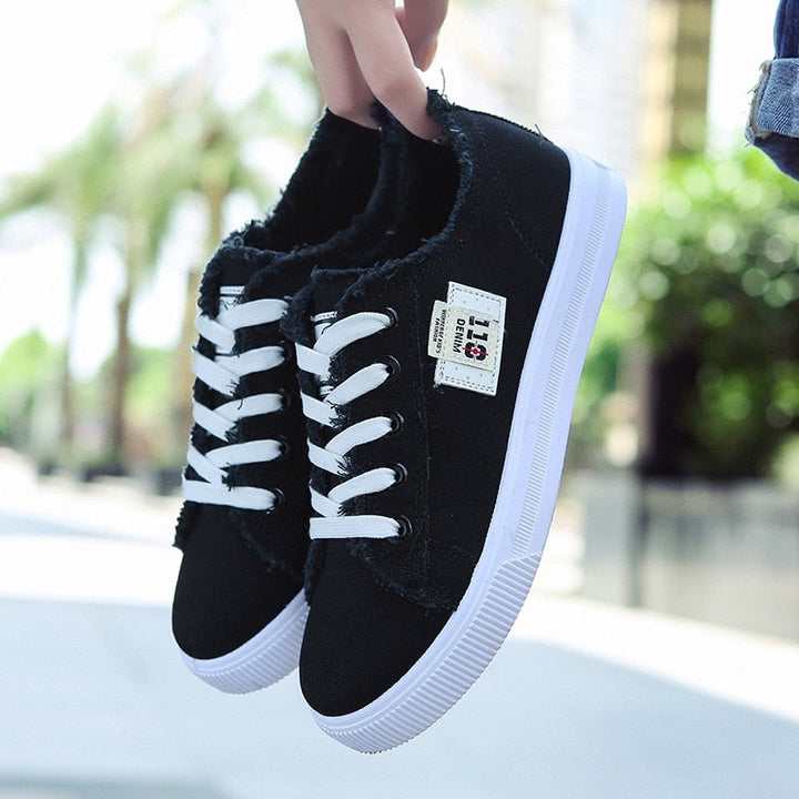 Schwarze Canvas-Sneaker mit weißer Sohle und Schnürsenkeln, lässige Straßenschuhe.