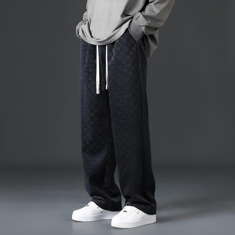 Graue Herren-Hose mit Kordelzug, kariertes Muster, lässiger Stil, weiße Sneaker.