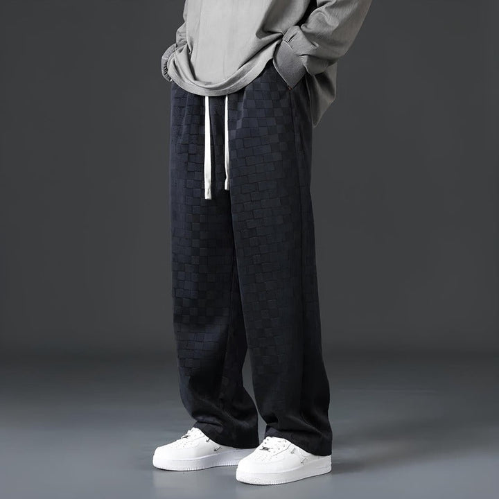 Graue Herren-Hose mit Kordelzug, kariertes Muster, lässiger Stil, weiße Sneaker.