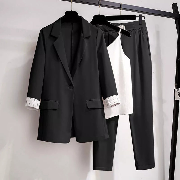 Schwarzer Damenanzug mit Blazer, Hose und weißem Top, elegantes Business-Outfit.