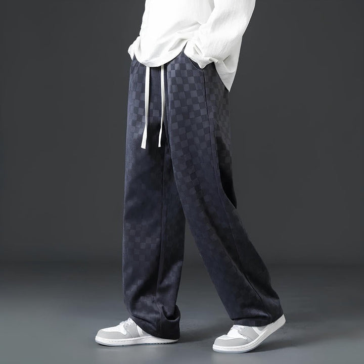 Dunkle karierte Hose, lässig, Herrenmode, Streetwear, mit weißen Sneakers und Hemd.