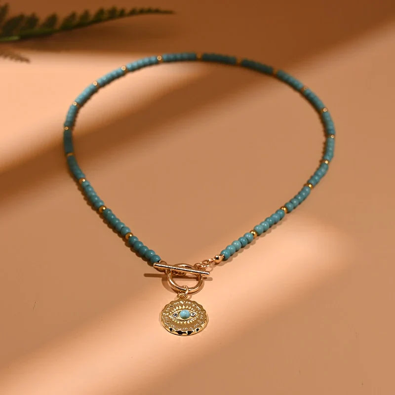 Türkisfarbene Perlenkette mit goldfarbenem Anhänger, eleganter Schmuck für Damen.