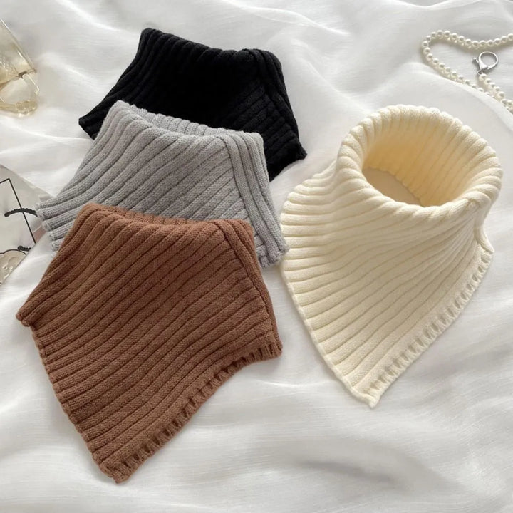 Vier gestrickte Rollkragen-Schals in Schwarz, Grau, Braun und Creme auf weißem Hintergrund.