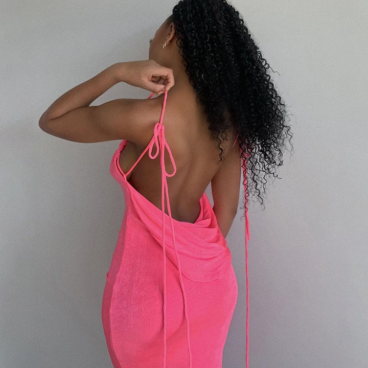 Frau in rosa rückenfreiem Kleid, Sommermode, elegantes Design, lockiges Haar, trendige Kleidung.