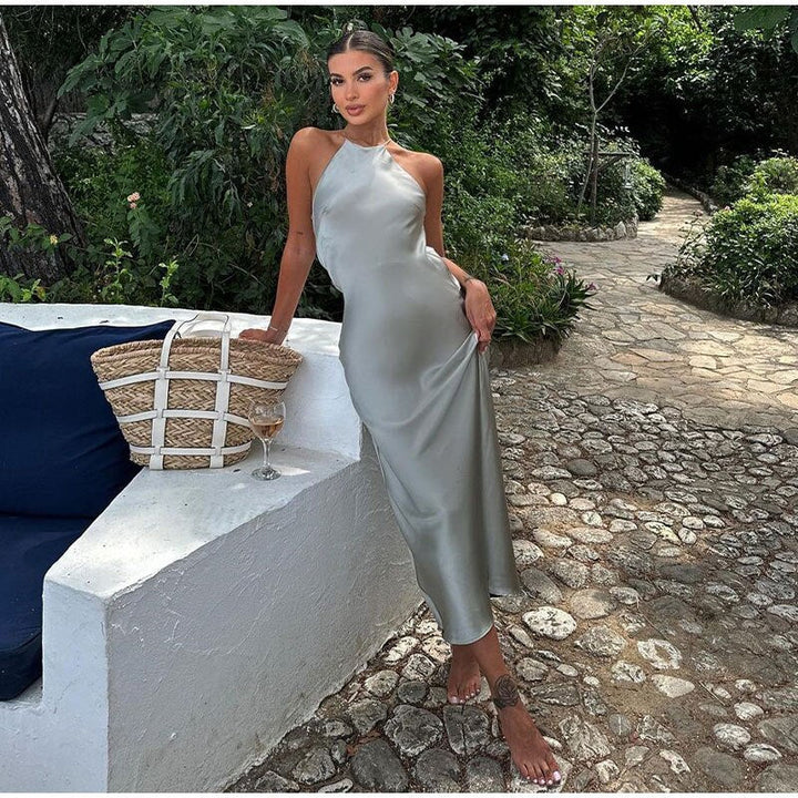 Frau in silbernem Satin-Kleid, Sommermode, Garten, elegantes Abendkleid, stilvoll, modern.