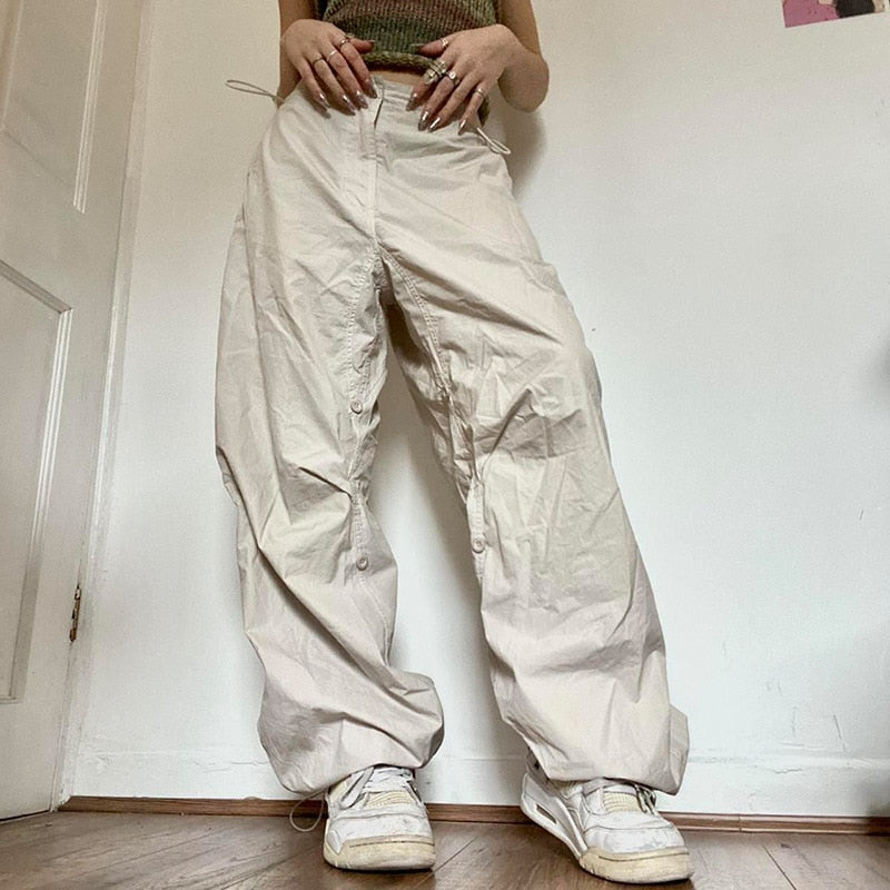 Damen weite beige Hose, Baumwolle, lässig, modisch, Streetwear, mit weißen Sneakers.