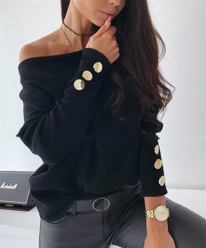 Frau in schwarzem Pullover mit goldenen Knöpfen, Lederhose, Armbanduhr, modisch, elegant.