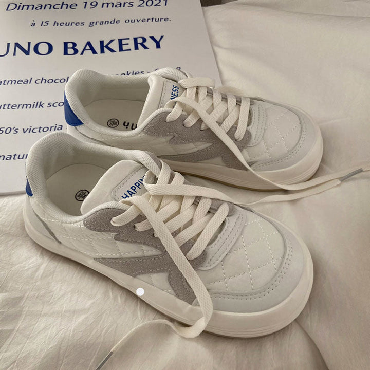 Weiße und graue Sneaker aus Leder mit blauen Akzenten auf weißem Hintergrund.
