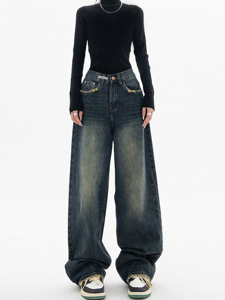 Frau in schwarzem Pullover und weiten Jeans, Streetwear-Mode, lässiger Stil.