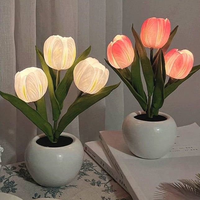 Zwei LED-Tulpenlampen in weißen Keramiktöpfen auf Tisch, dekorative Beleuchtung.