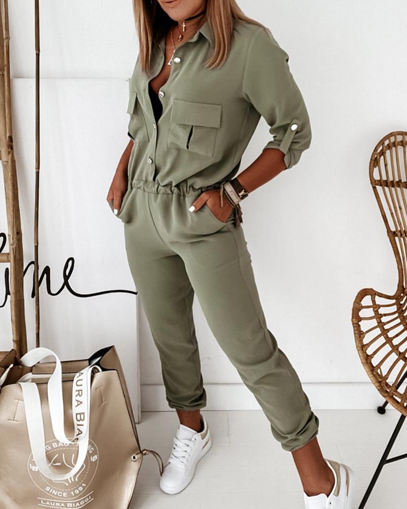Frau in olivgrünem Jumpsuit, Taschen, weiße Sneaker, beige Tasche, modisch, lässig.