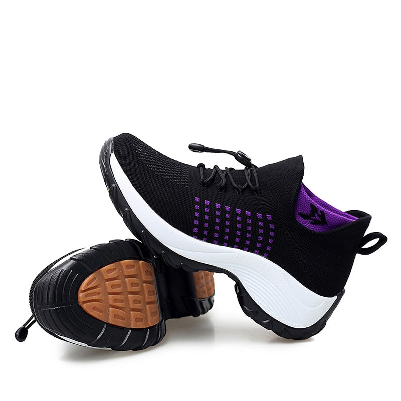 Schwarze Sportschuhe mit lila Akzenten, rutschfeste Sohle, atmungsaktives Mesh-Material.