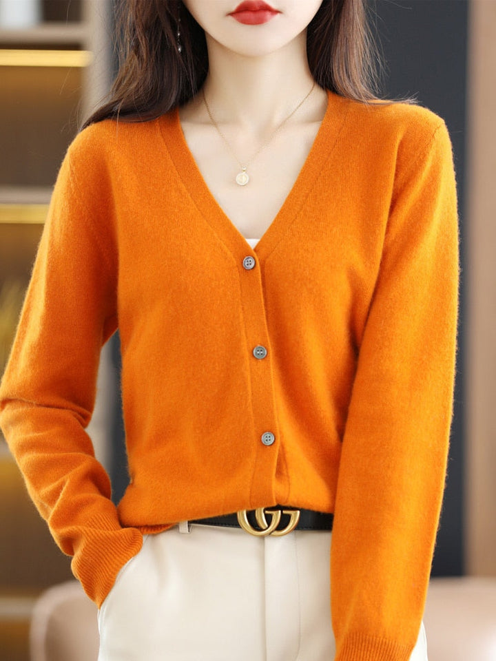 Frau in orangefarbener Strickjacke, V-Ausschnitt, Knöpfe, eleganter Herbstlook, Damenmode.