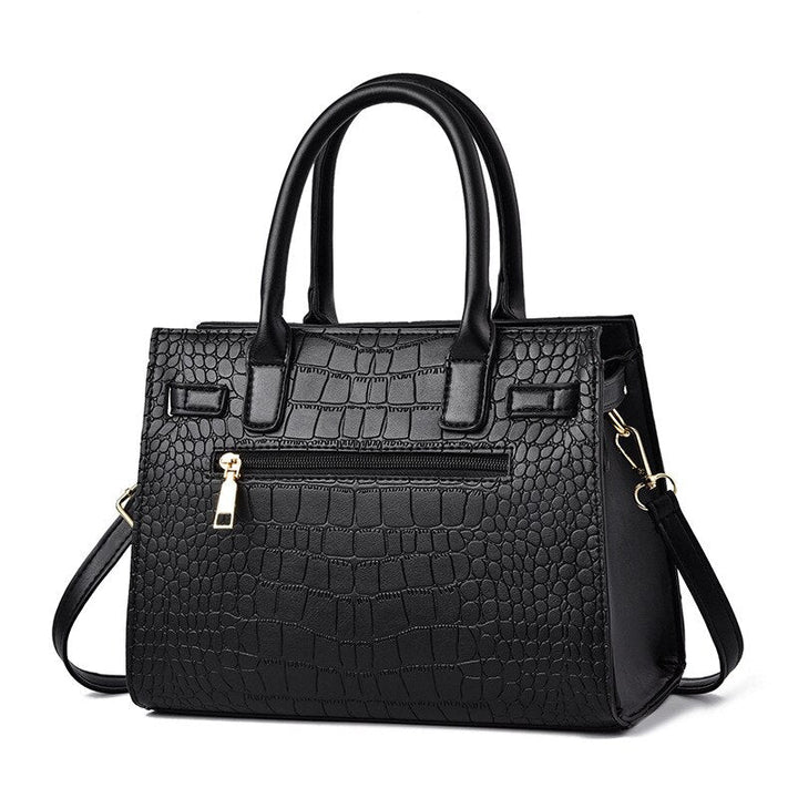 Schwarze Damenhandtasche aus Kunstleder mit Krokodilprägung und abnehmbarem Schulterriemen.
