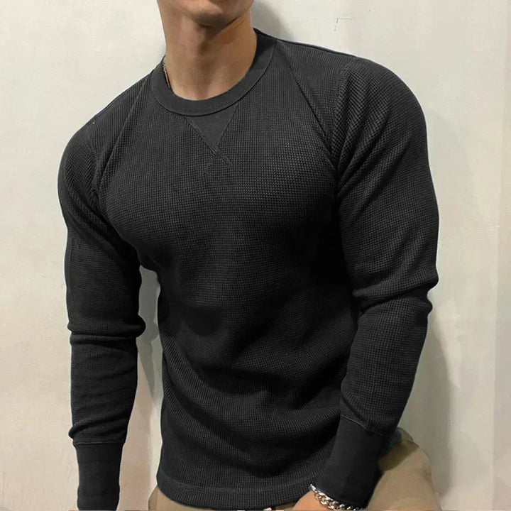 Mann in schwarzem Langarmshirt, Baumwolle, sportlich, modisch, Freizeitkleidung, Herrenmode.