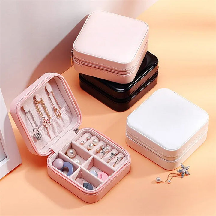 Rosa Schmuckkästchen aus Leder mit Fächern für Ohrringe und Ketten, tragbar, elegant.