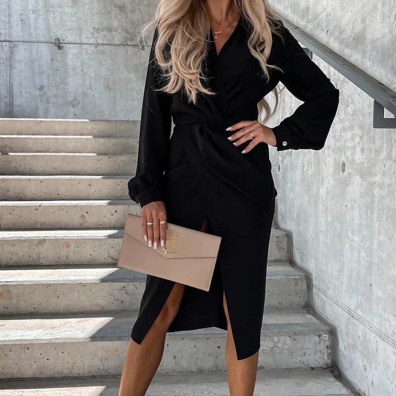 Elegantes schwarzes Wickelkleid Damenmode, langärmelig, mit beigem Clutch auf Treppe.