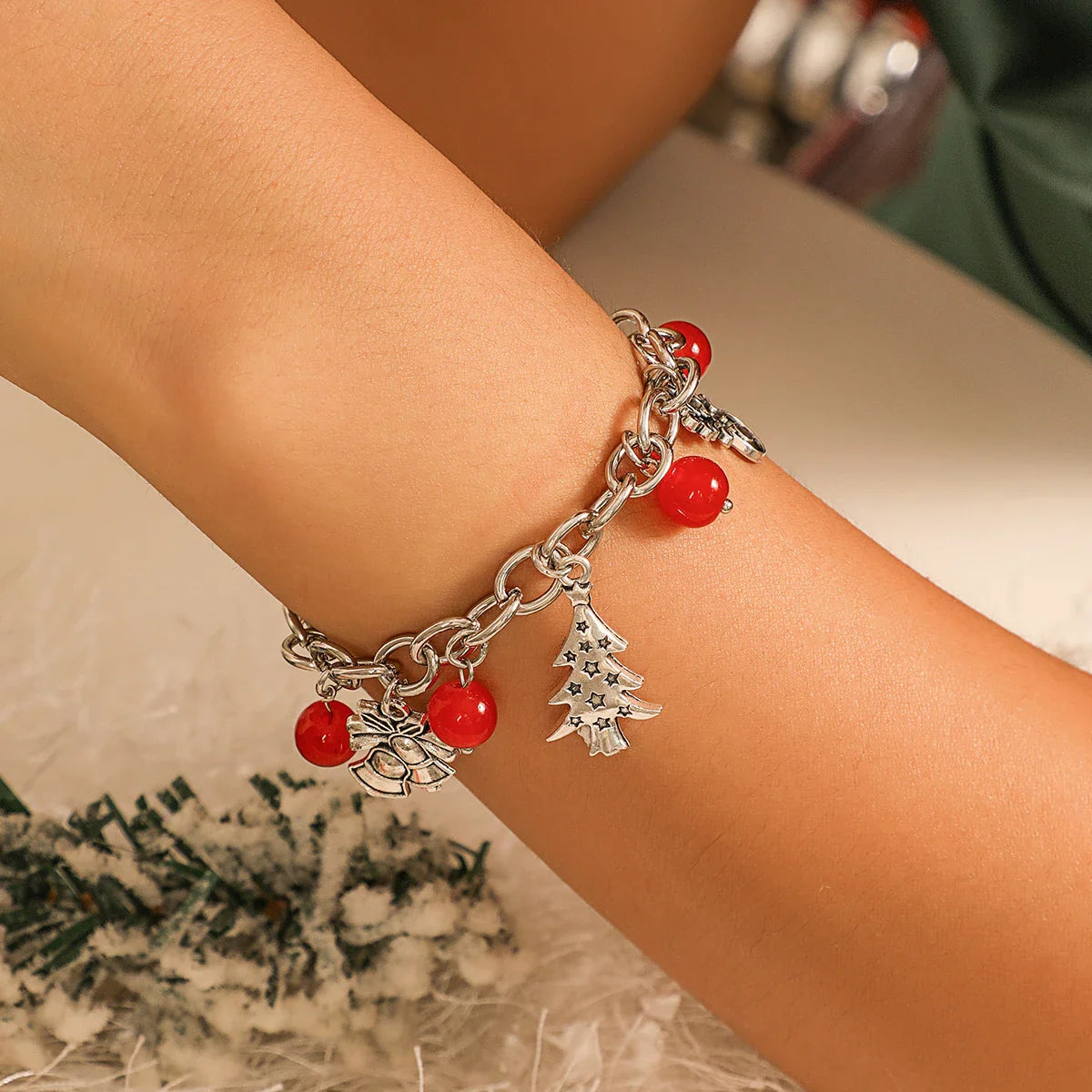 Silbernes Armband mit roten Perlen und Weihnachtsbaum-Anhänger, festlicher Schmuck.