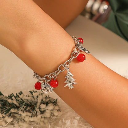 Silbernes Armband mit roten Perlen und Weihnachtsbaum-Anhänger, festlicher Schmuck.