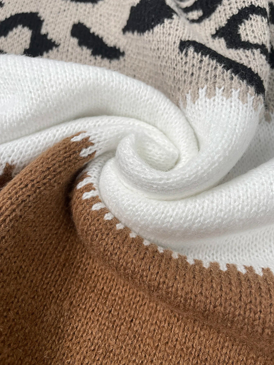 Nahaufnahme gestrickter Pullover, beige-weiß, Leopardenmuster, weiche Baumwolle, modisch.