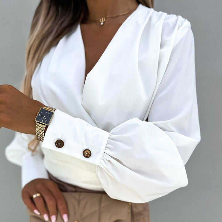 Frau in weißer Bluse mit Ballonärmeln und goldener Uhr, elegantes Outfit, Modeaccessoires.