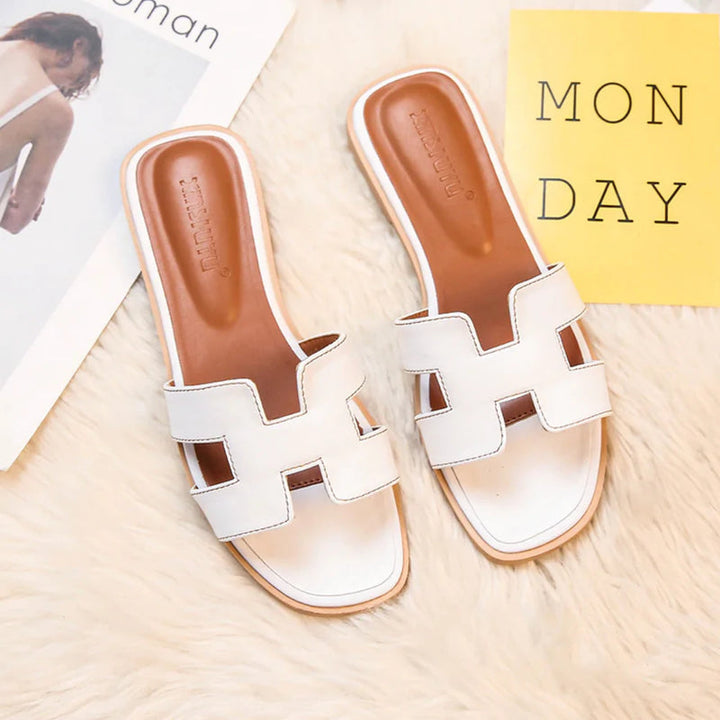 Weiße Damen-Sandalen aus Leder auf Teppich, modisch, bequem, Sommermode.