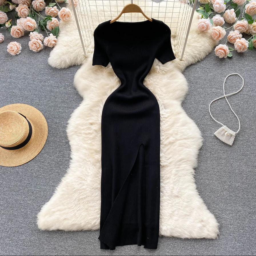 Schwarzes Abendkleid mit Schlitz, elegant, figurbetont, auf weißem Fell, umgeben von Rosen.