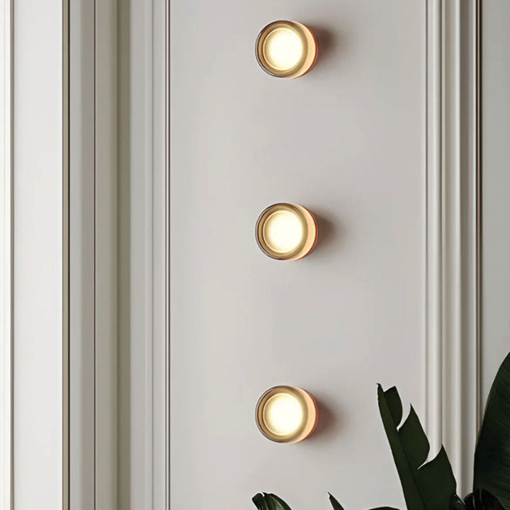 Drei runde LED-Wandleuchten, goldfarben, modernes Design, Innenbeleuchtung, vertikale Anordnung.