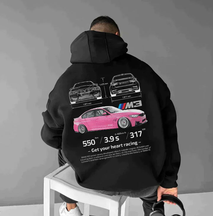 Mann in schwarzem Hoodie mit pinkem Auto-Design und technischen Details, sportlich, modern.