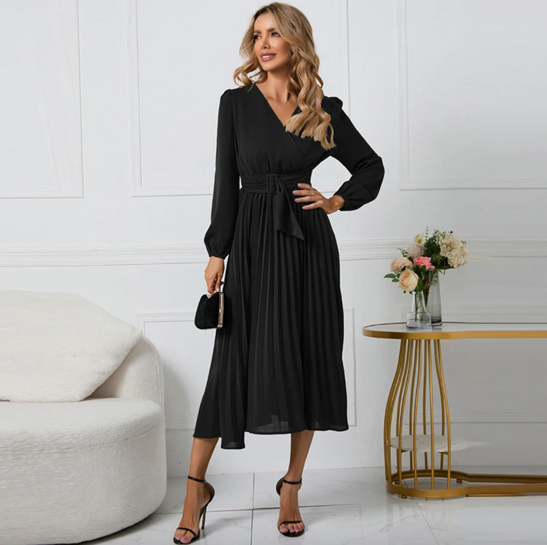Frau in elegantem schwarzen Abendkleid, stehend neben Tisch mit Blumen, modisch, stilvoll.