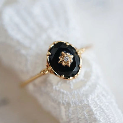 Goldener Ring mit schwarzem Onyx und Diamant, elegantes Schmuckstück für Damen.